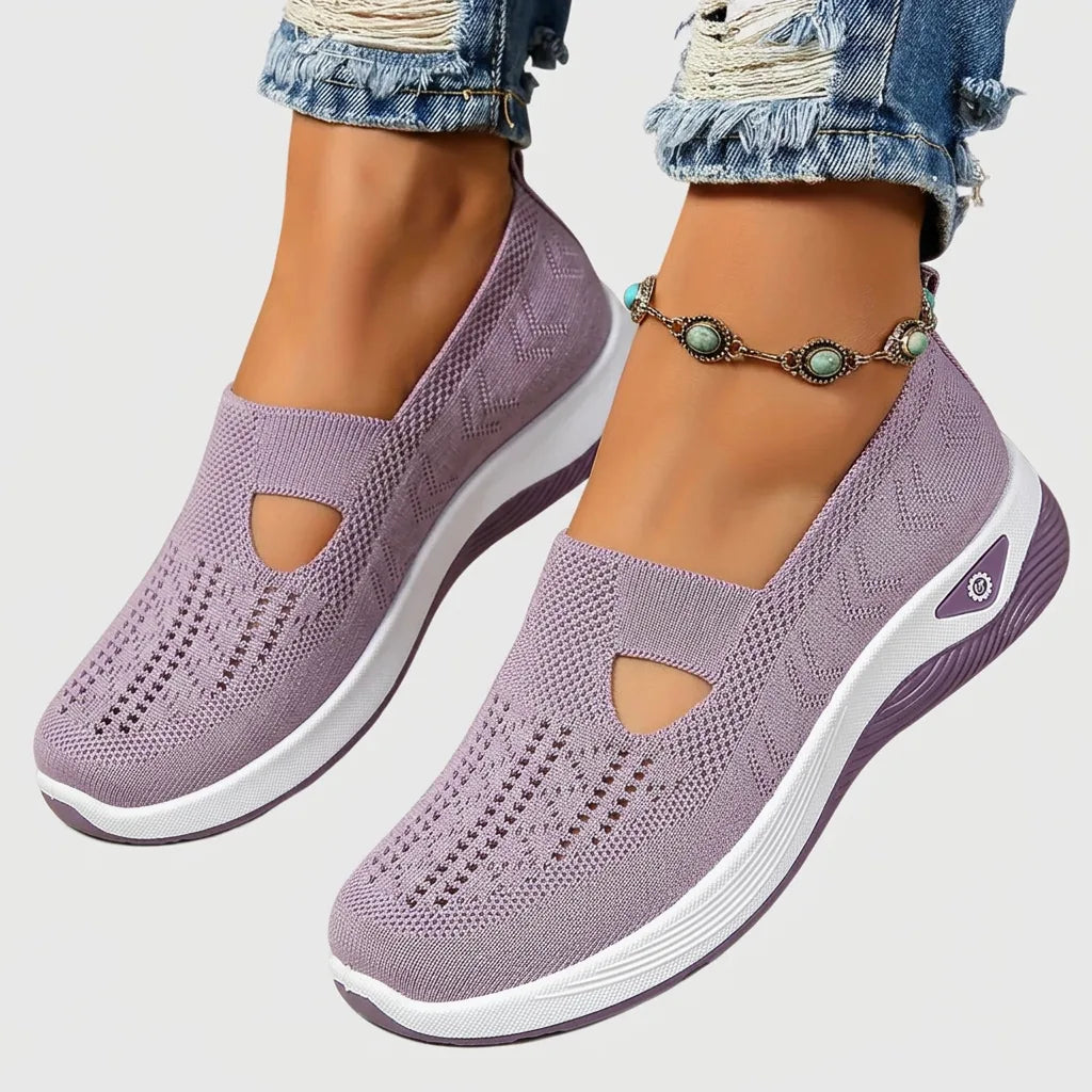 Close-up side view of dusty purple knitted slip-on sneakers with cut-out detail and white chunky sole, worn with ripped jeans