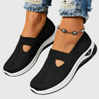 Black knitted slip-on sneakers shown from the side with teardrop cut-out detail and contrasting white platform sole