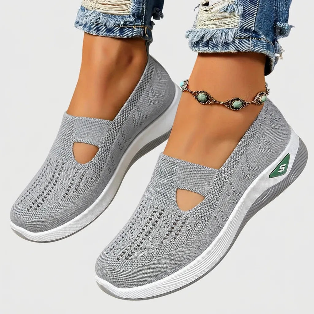 Light grey knitted slip-on sneakers with perforated texture, cut-out vamp and white wedge sole, paired with an anklet