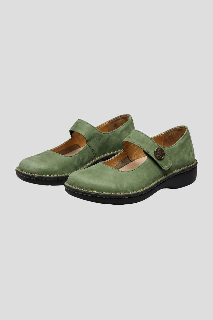 Pair of green nubuck Mary Jane flats with button strap closure and black stitched sole, angled view
