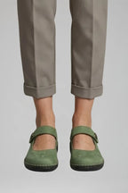 Front view of ankle-length cuffed trousers worn with green nubuck Mary Jane flats