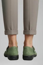 Back view of cuffed trousers paired with green Mary Jane flats showing the stitched heel seam