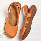 Orange leather slingback flats shown from above revealing the tan contoured footbed and the ridged cork-look outsole.