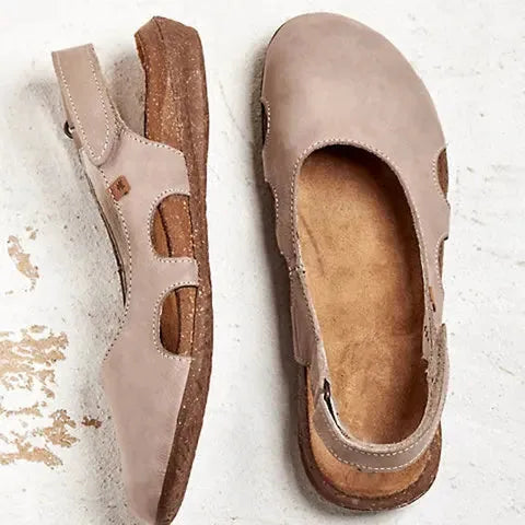Taupe leather slingback flats displayed from above and side, highlighting the stitched cut-outs and soft suede-lined insole.