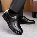 Side profile of black leather slip-on shoe in motion, showing flexible sole tread against a carpeted floor