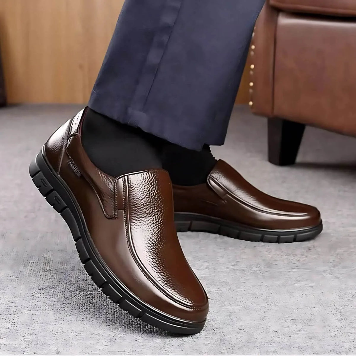 Walking shot of brown leather slip-on shoes paired with dark trousers, showing the smooth vamp and low-profile heel