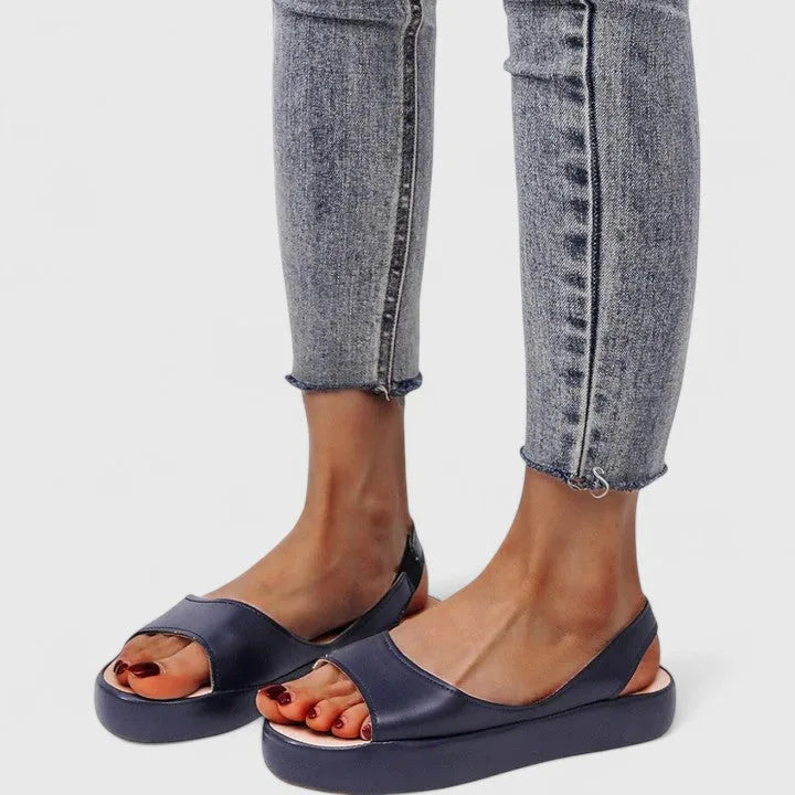 Navy slingback platform sandals paired with grey cropped skinny jeans, close-up side angle