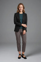 Woman wearing a black blazer, teal jumper and grey trousers styled with black crisscross strap wedge flats