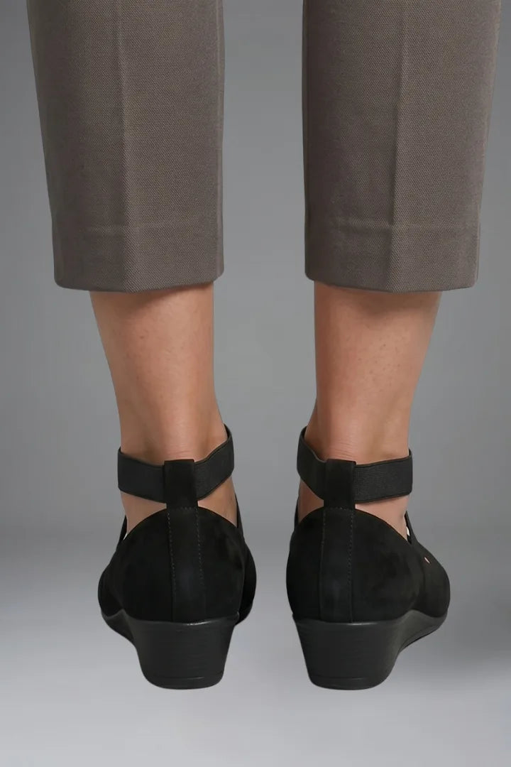 Back view of black suede flats showing the heel cup, wedge sole and crossed elastic straps