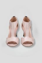 Pair of soft pink suede sandals shown from above, featuring a peep toe and curved cutout side panels