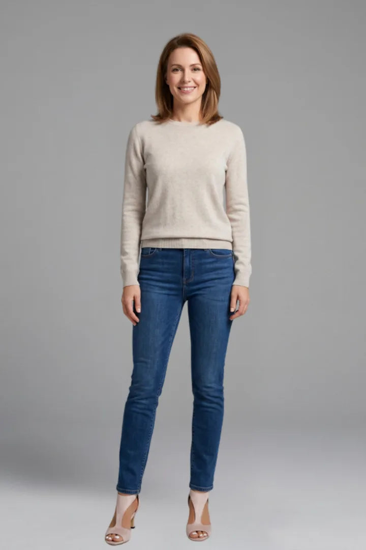 Woman wearing an oatmeal jumper, jeans and pink heeled sandals in a full-length styling shot