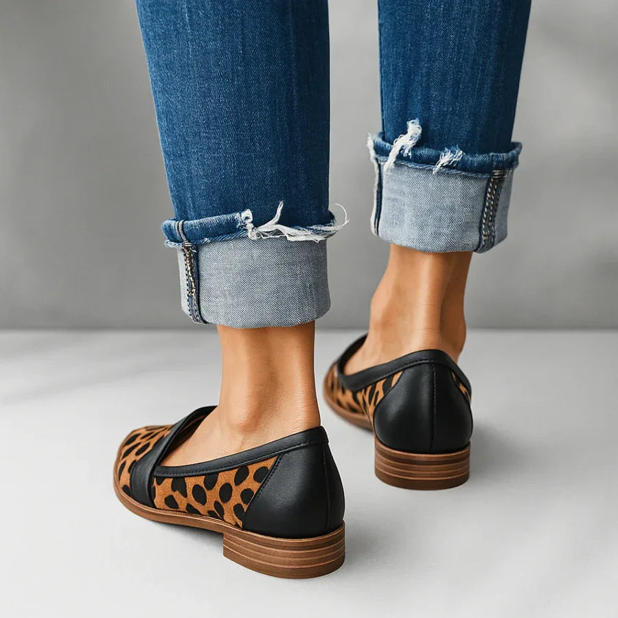 Back view of leopard-print pony hair loafers with black leather trim and stacked wooden heel