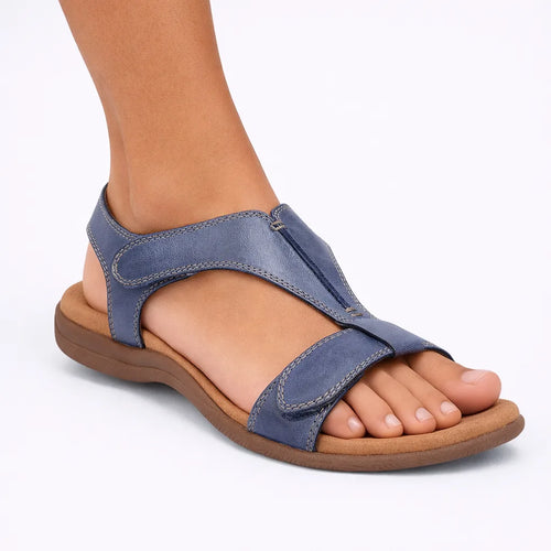 Side view of a blue faux leather T-strap sandal with adjustable touch-fasten straps and a cushioned tan footbed