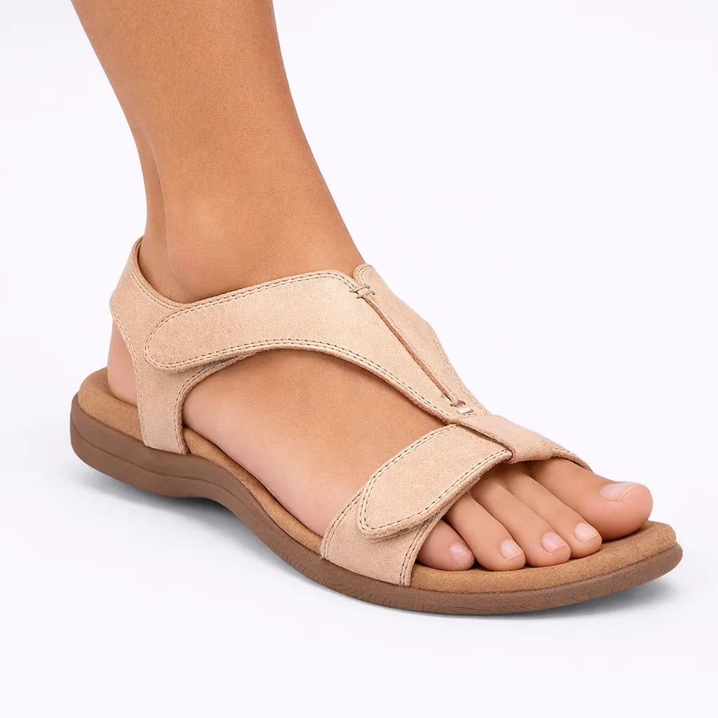 Beige T-strap sandal showing the soft padded insole and low stacked heel from the side