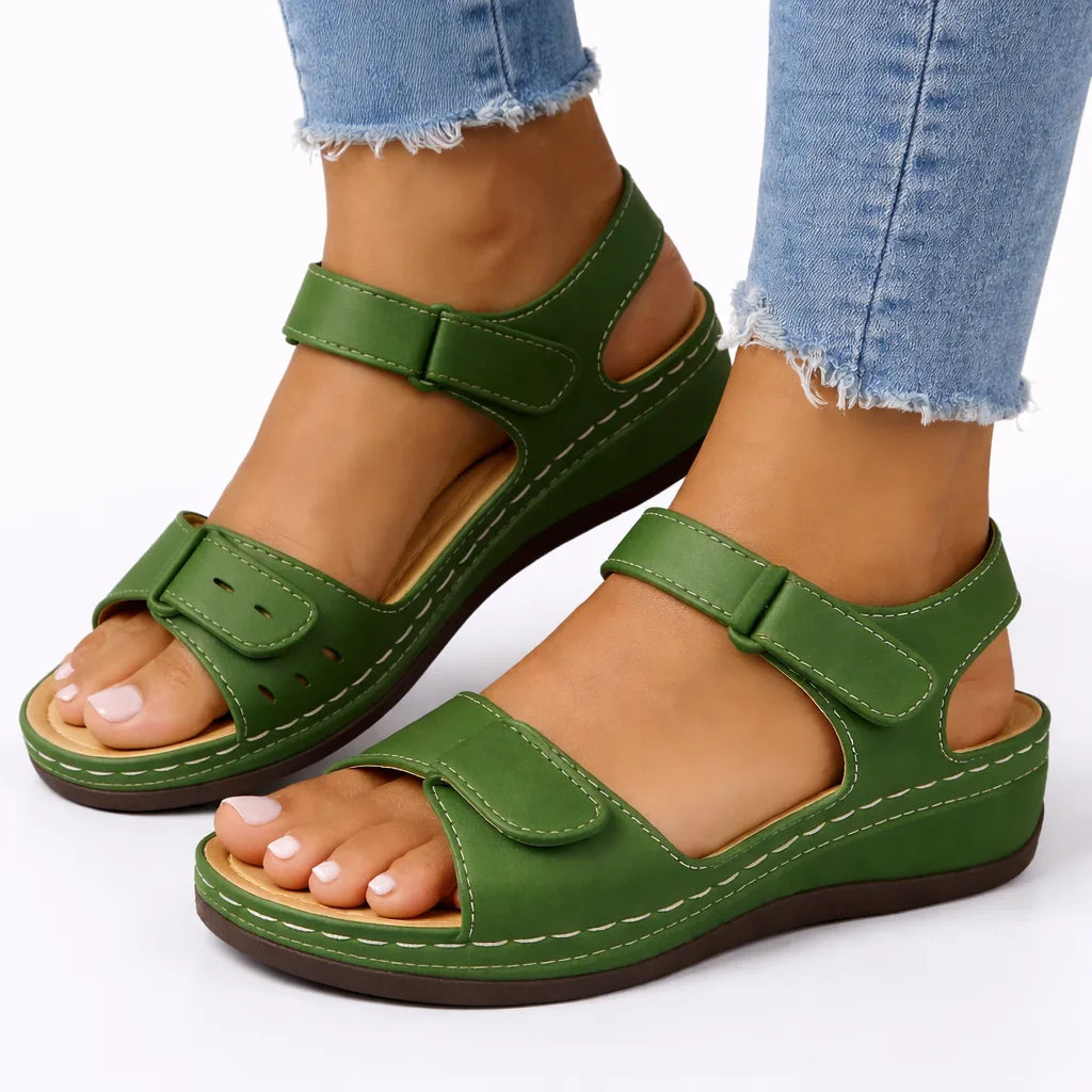 Green leather-look wedge sandal with hook-and-loop straps and perforated toe strap, worn on foot