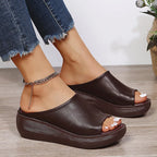 Angled view of white peep-toe wedge slides showing the rounded toe and ridged heel edge