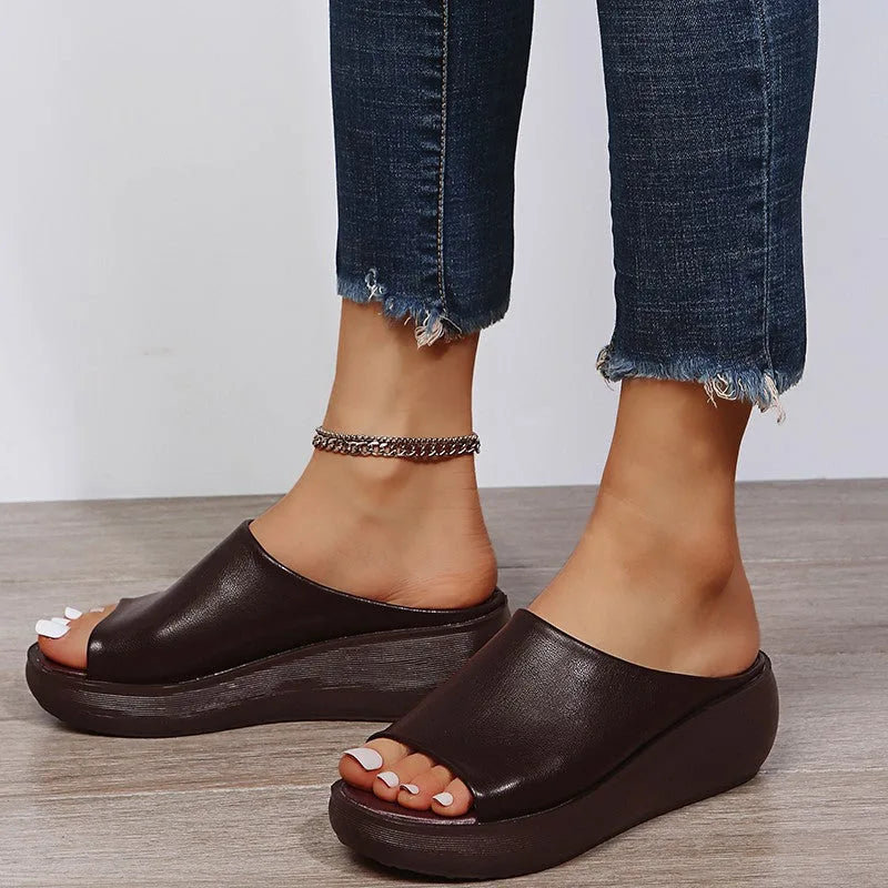 Close-up of white slide sandal showing the curved vamp and slip-on open-heel design