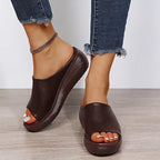 Front view of brown peep-toe wedge slide highlighting the deep wine-toned footbed