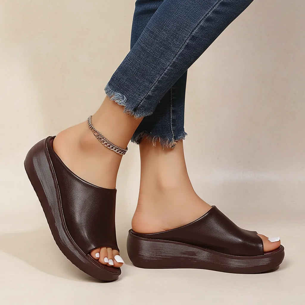 Dark brown peep-toe wedge slide with black platform sole, paired with a layered chain anklet