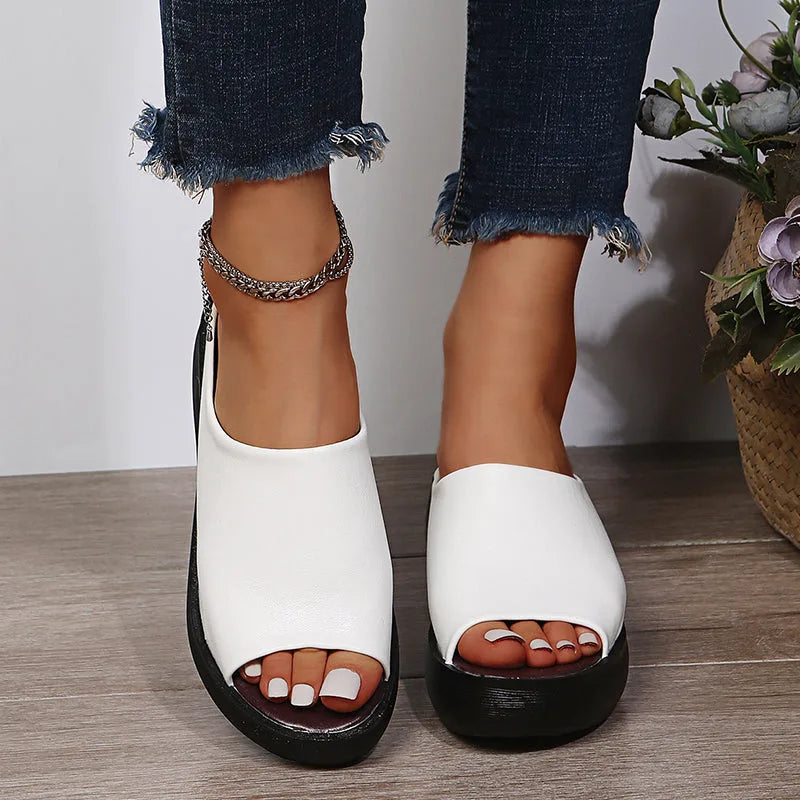 White slip-on wedge slide shown with a chain anklet draping over the open heel