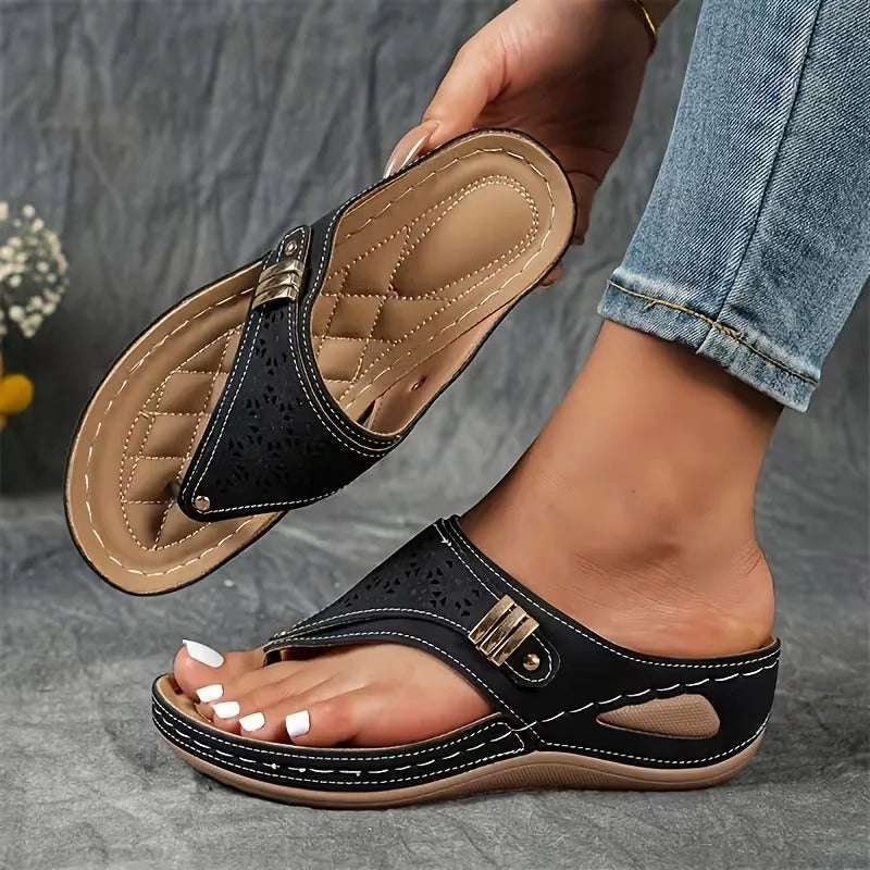 Blue wedge sandal shown on foot with contrast stitching, toe-post strap and buckle detail against grey backdrop