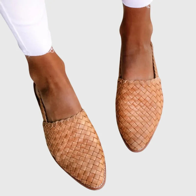 Close-up of tan woven leather slingback flats with pointed toe, worn with white cropped jeans