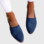 Navy blue woven leather slingback flats with pointed closed toe, worn on bare feet