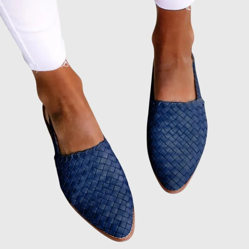 Navy blue woven leather slingback flats with pointed closed toe, worn on bare feet