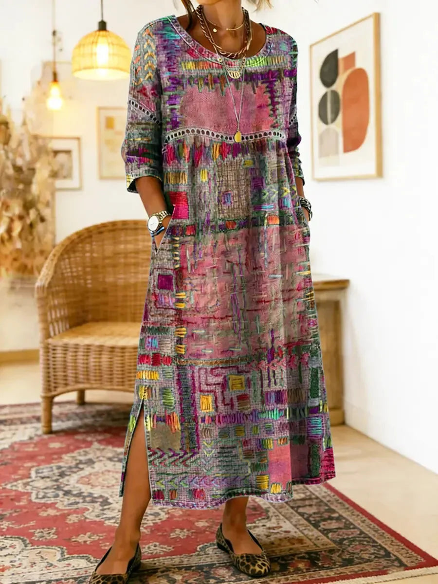 Pink and grey patchwork-print dress worn with layered necklaces, showing the drop-waist seam and side pocket