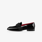 Front angled view of navy velvet loafers highlighting the folded bow and patent toe cap