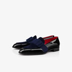 Angled front view of navy velvet loafers with black patent leather toe and red interior lining