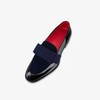 Side profile of navy velvet and black patent leather loafer with grosgrain ribbon bow