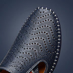 Macro close-up of the perforated toe panel showing the fine pinhole pattern and contrast white whipstitching