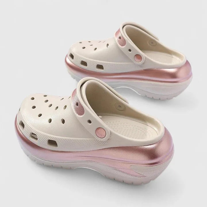 Side view of cream and metallic pink clog with perforated upper, ridged outsole and adjustable heel strap