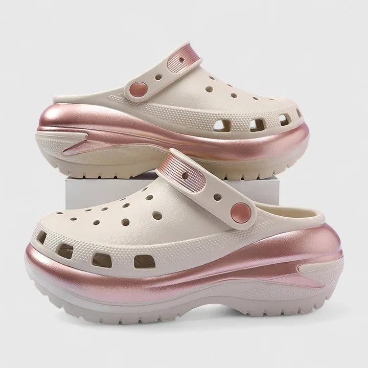 Side profile of cream clog with pink metallic trim, perforated vamp and chunky lugged platform sole