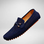 Navy suede perforated driving loafer shown at an angle, with orange rubber pebble sole and woven lace detail