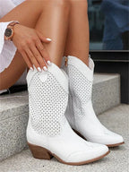 Front view of white perforated leather western boots worn with white dress, showing scalloped shaft detail