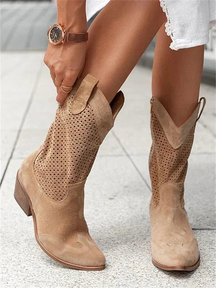Tan suede perforated western boots worn while being adjusted, showing scalloped shaft and side zip