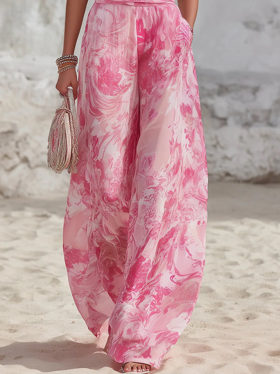 Close-up of the wide-leg trousers with the pink marble print and a hand resting in the side pocket