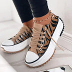 Front angled view of black platform sneaker with white toe cap and visible star detail on the tread sole