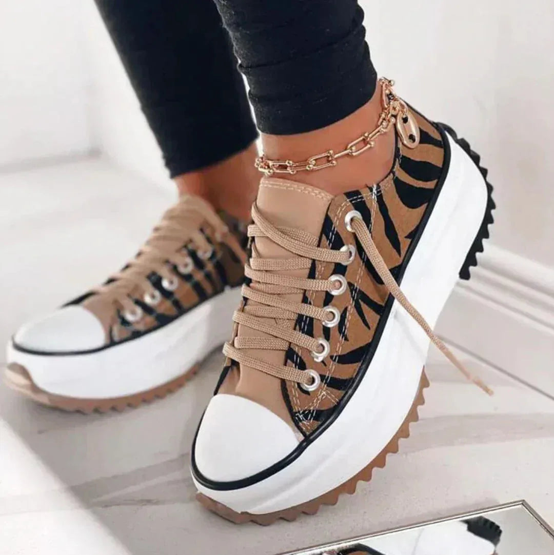 Front angled view of black platform sneaker with white toe cap and visible star detail on the tread sole
