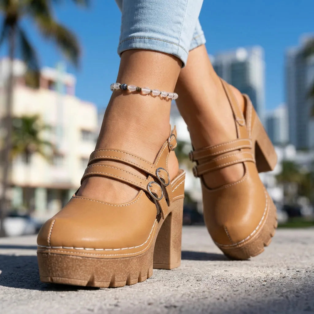 Tan platform Mary Jane clog heels with double crossover straps and buckles, worn with cuffed denim jeans