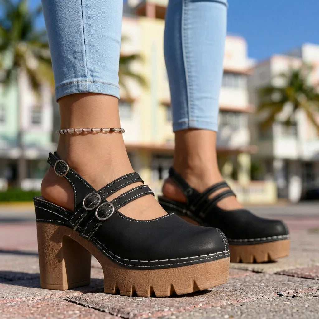Black platform slingback clogs with double Mary Jane straps and contrast stitching, worn walking outdoors