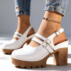 White slingback platform heels with double straps and gold buckles, side profile on light background