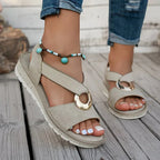 Close-up of beige sandals on foot showing padded platform sole, turquoise beaded anklet and crisscross straps