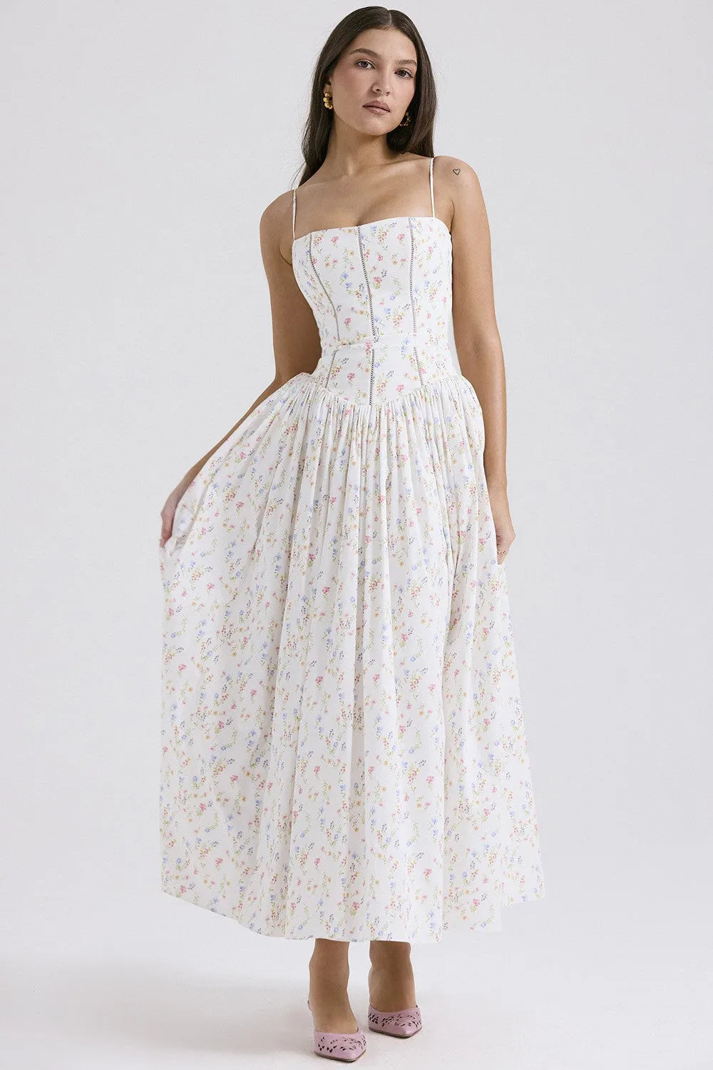 Close view of the pleated waist seam and gathered skirt detail on a floral corset midi dress