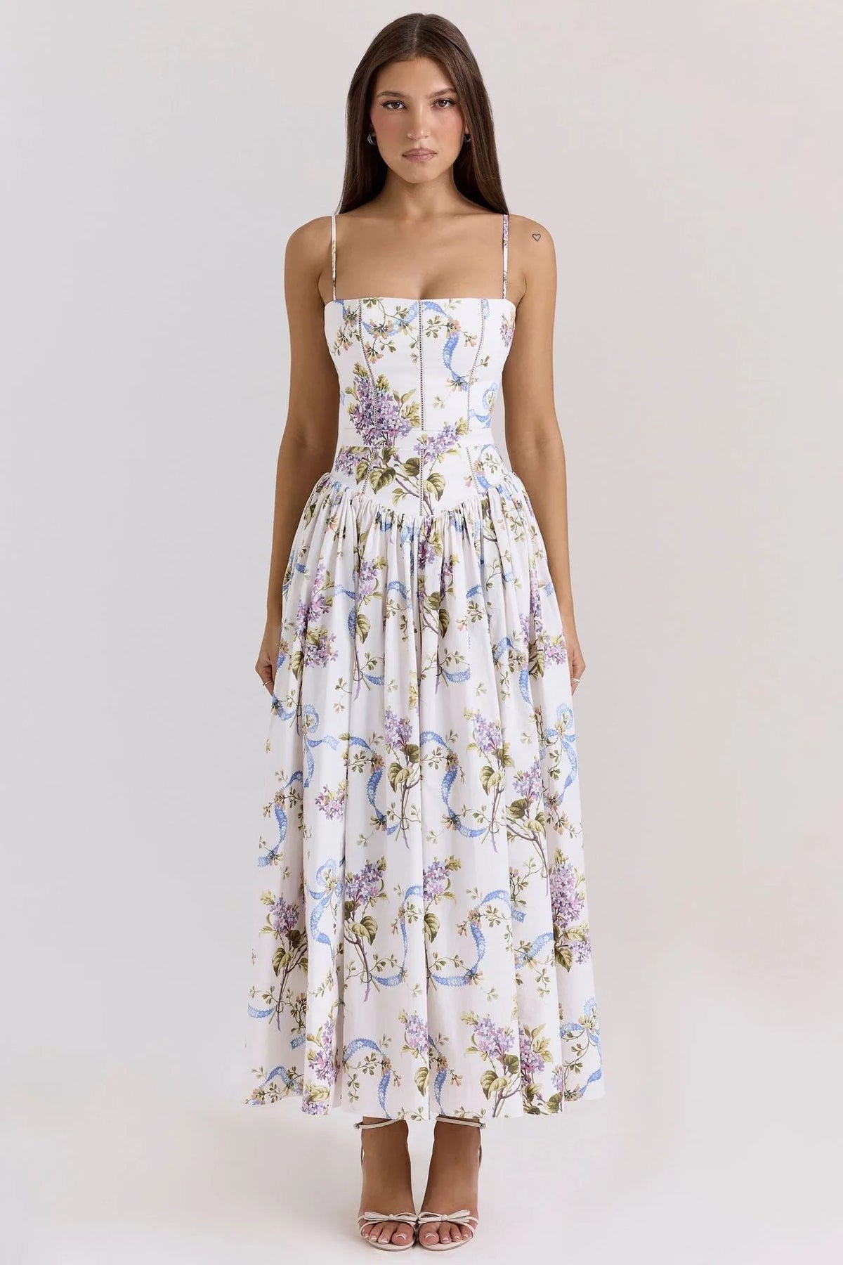 Side view of a strapless white floral corset dress with visible boning seams and a full pleated skirt