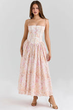 Full front view of a white and blue grand floral corset midi dress with spaghetti straps and heels