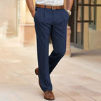 Rear view of man in navy pleated dress pants with brown leather belt and brown lace-up shoes