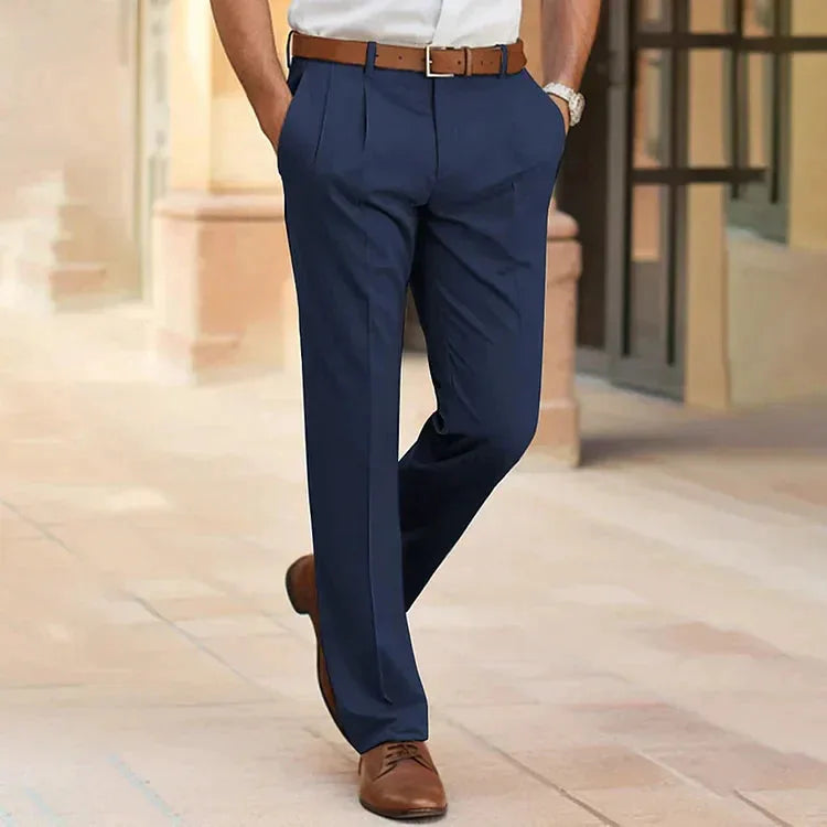 Rear view of man in navy pleated dress pants with brown leather belt and brown lace-up shoes